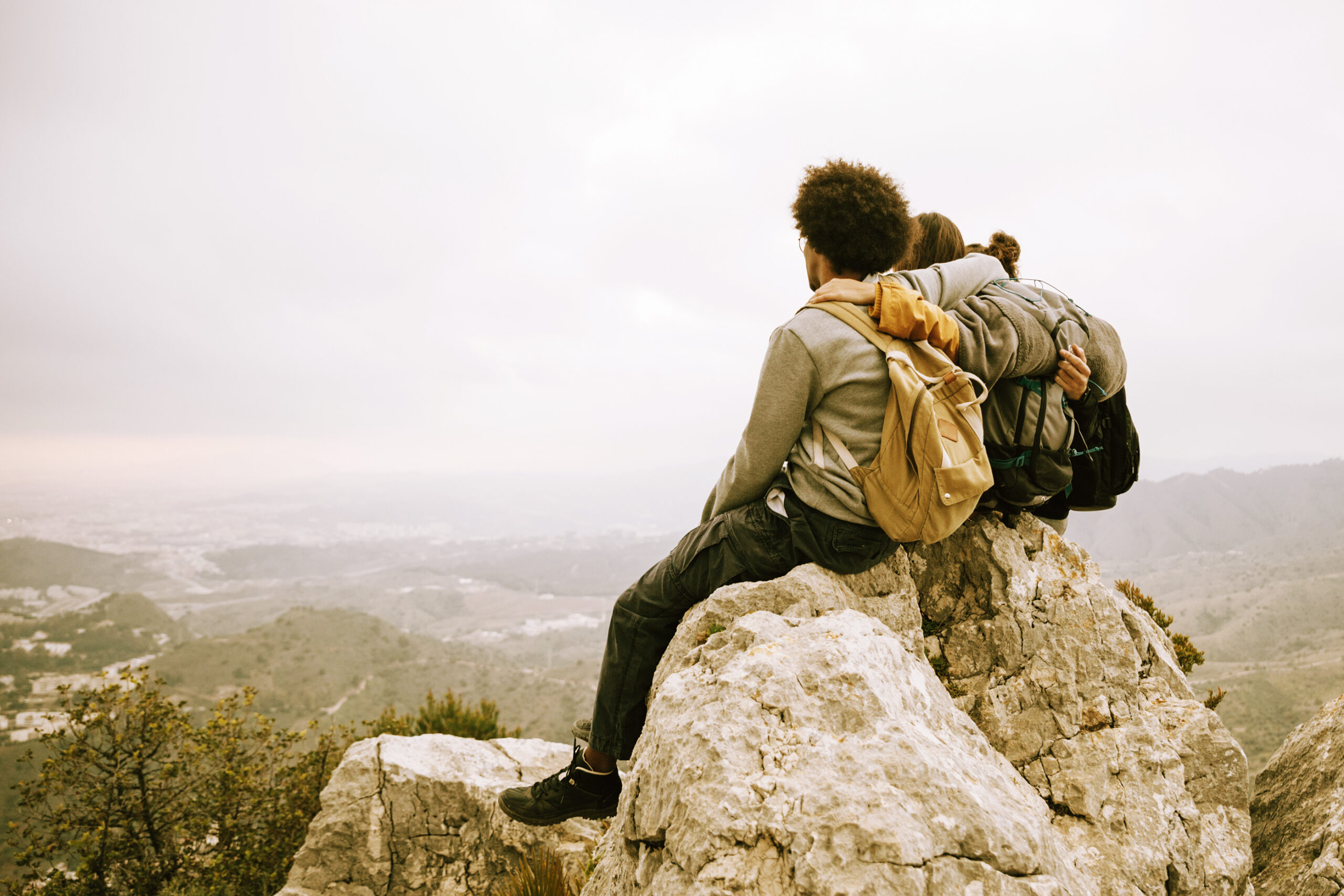 two male hiker sitting top rock mountain looking scenic viewcopy 2 scaled